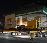Photo of the historic Walker House on dollies in transit during the nighttime.